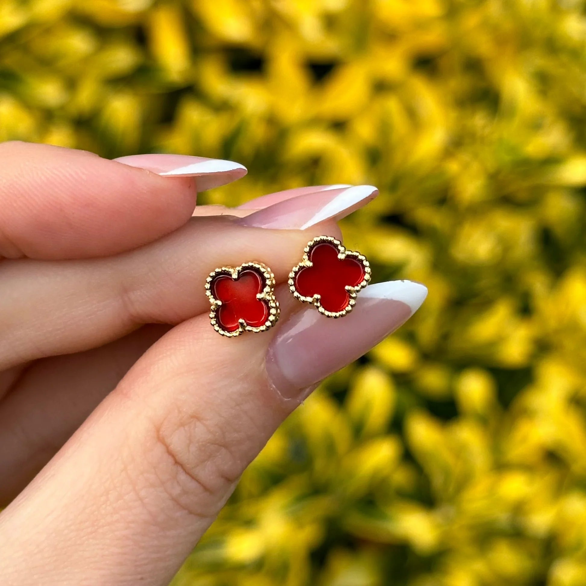 Elegant 18k gold earrings featuring vibrant red carnelian clover pendants, a luxury lucky charm accessory. - Seven Gates