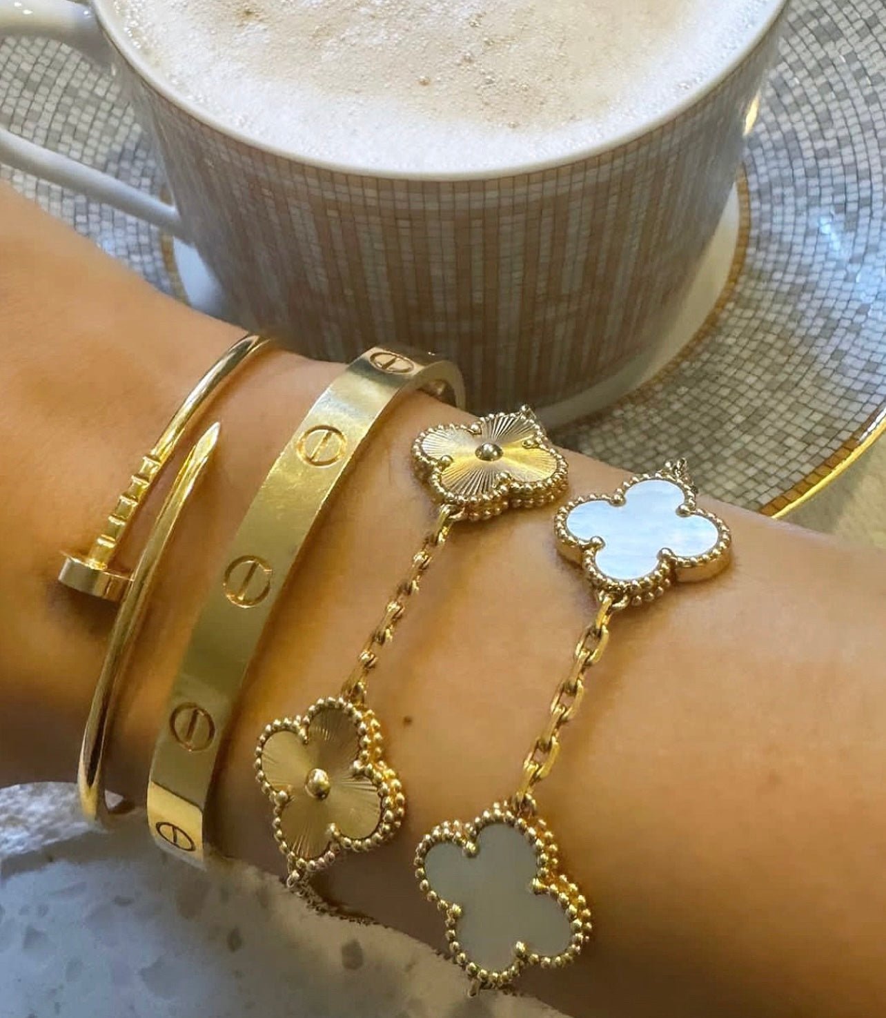 Minimalist full gold bracelet with five clover motifs, capturing the "quiet luxury" aesthetic in 18k gold.